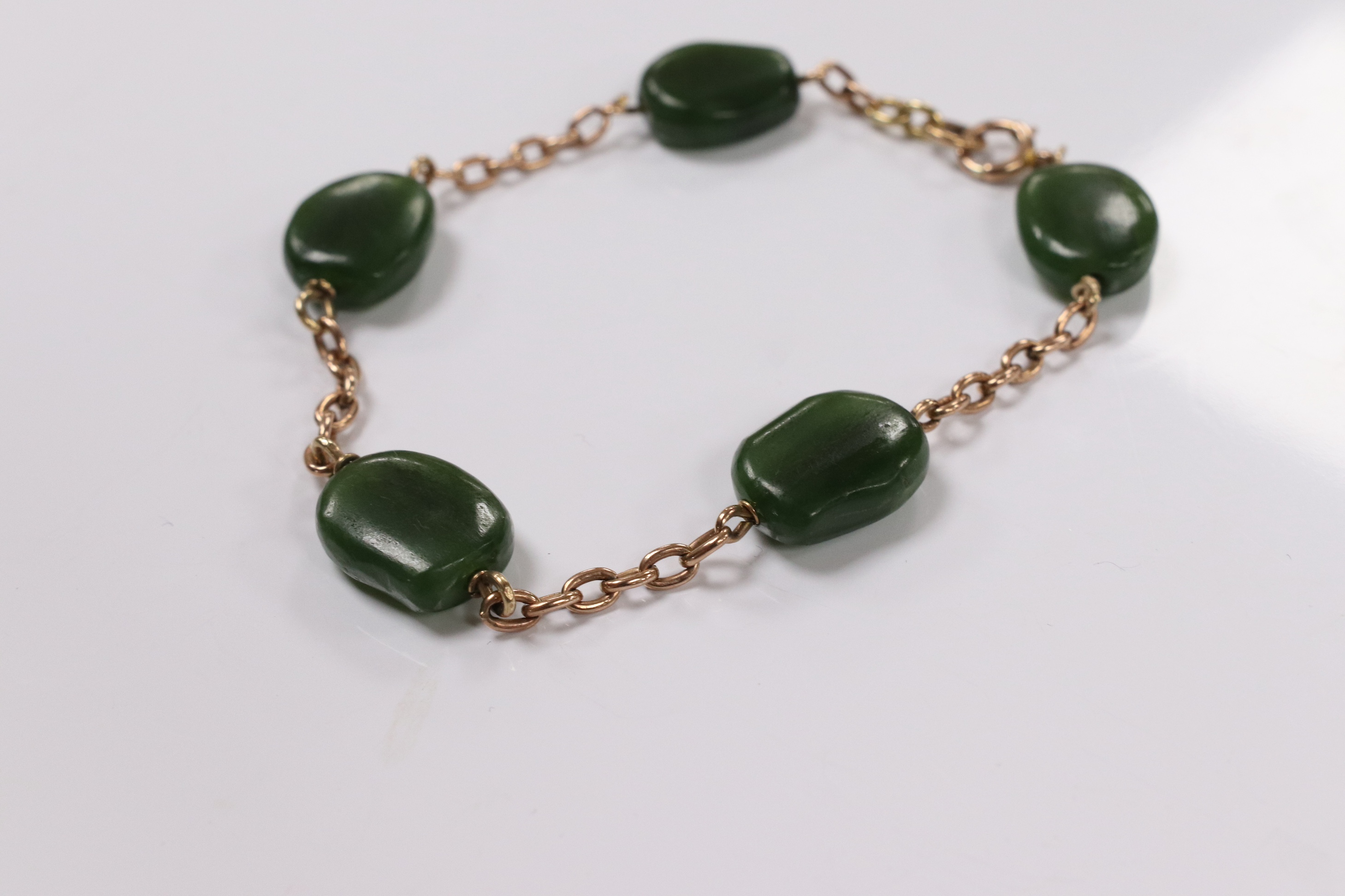 A 9ct and five stone jade bead set bracelet, 19cm, gross weight 15.2 grams. Condition - fair